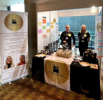 A promotional booth with staff, banners, and merchandise at an event.