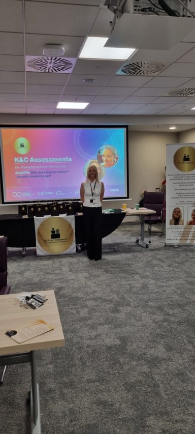 Special guests at the National Association of Supported Accommodation Conference A speaker stands at a podium in a conference room with a vibrant presentation backdrop.